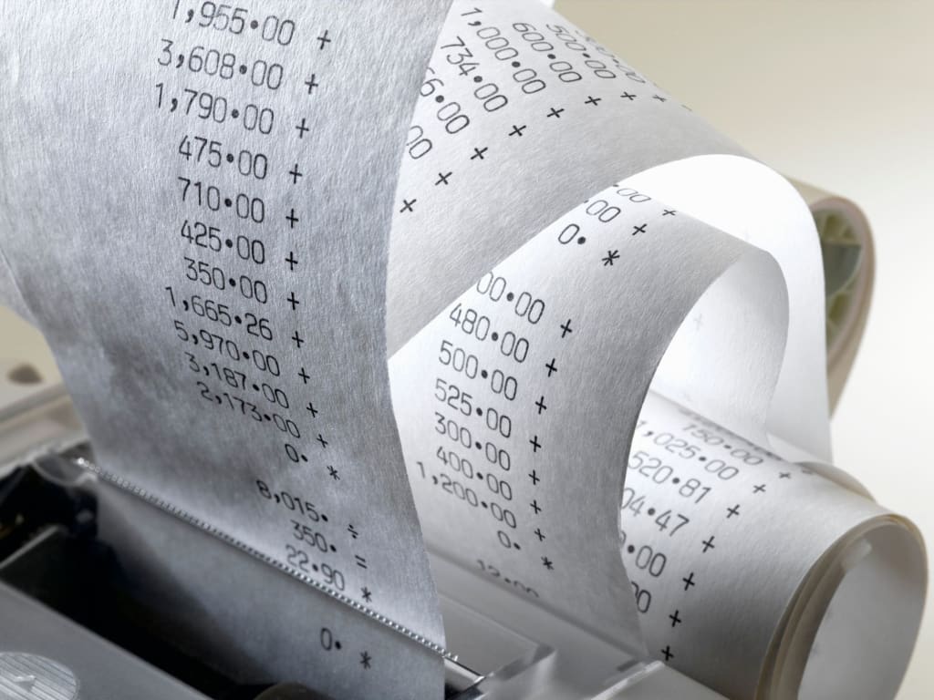 A long white receipt curling out of a financial calculator showing lots of itemised savings.